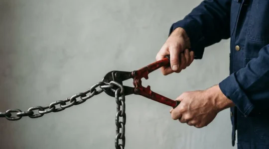 A person cutting through heavy chains with determination, symbolizing breaking free from high-interest debt